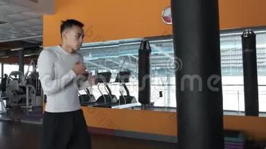 一个年轻的亚洲人正在跆拳道健身房训练。