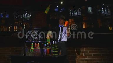 <strong>杂技表演</strong>由巴曼杂耍两个瓶子和烧杯进行混合。 酒吧背景。 慢动作