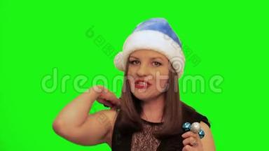 戴着<strong>圣诞</strong>帽的漂亮女人微笑着唱<strong>圣诞歌</strong>，唱着绿色的彩幕