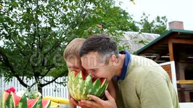夏天，在花园里，爸爸和一个四岁的儿子切了一个<strong>西瓜</strong>，<strong>吃</strong>了它，玩得开心，一个男孩喜欢<strong>西瓜</strong>