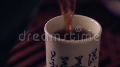 中国传统茶道的动作.. 在一个杯子里把茶从茶壶里倒出来。 木制茶板