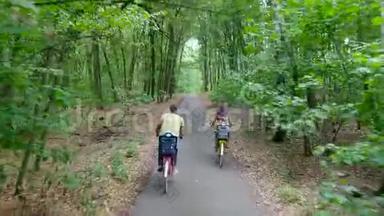 家人，父亲，母亲穿着一件连衣裙，带着一篮子花，和孩子们一起，骑自行车，在森林里