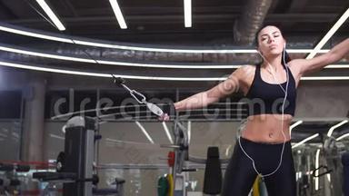 健身妇女在健身房用健身机电缆交叉进行锻炼
