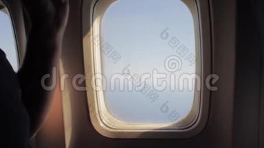 人打开一扇飞机窗户，在空中旅行时向外看。 很开心。 一起乘飞机旅行的人。 旅游概念