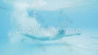 运动女孩潜入水下，在游泳池中积极向前移动
