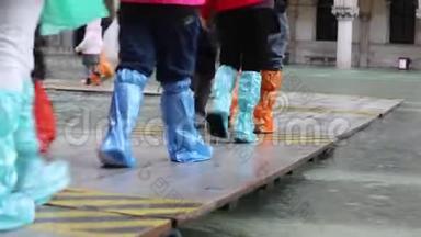 在威尼斯的洪水中，人们在人行道上行走
