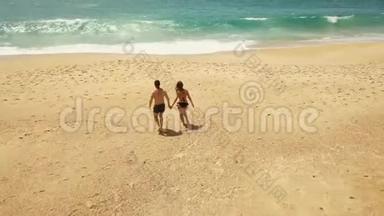 幸福的夫妇无忧无虑地跑到海滩上的水上。 葡萄牙美丽的海洋海岸
