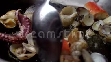 海鲜在平底锅中煎炸时用勺子混合。