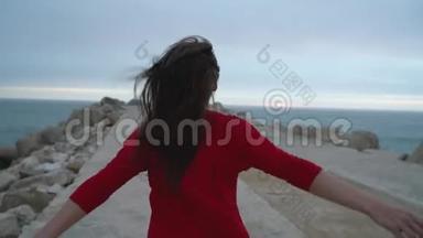 穿着红色衣服的女人跑到海边的灯塔