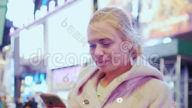 年轻迷人的女人在<strong>时代广场</strong>，纽约，美国。 在智能手机上输入文字