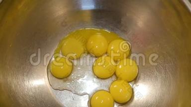 厨房柜台上的一个金属搅拌碗里的七个碎鸡蛋，准备<strong>敲打</strong>或搅拌它们来烘烤