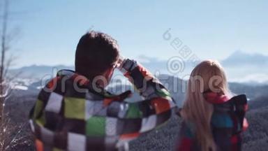 可爱的夫妇穿着五颜六色的滑雪服站在观景台上，看着华丽的山脉。 <strong>浪漫浪漫</strong>