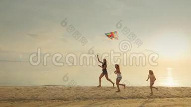 妈妈带着两个女儿在沙滩上玩风筝.. 好玩的一起跑
