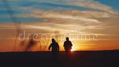团队合作商务旅行理念.. 两名游客走着生活方式的剪影走在自然的道路上，日落的阳光