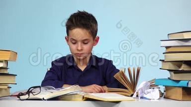 疲惫的男孩开始合上书，把书<strong>折起</strong>来。 蓝色背景