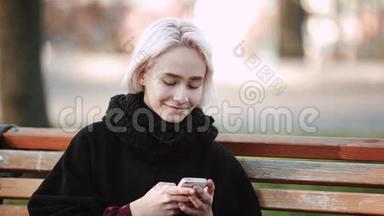外面的金发女孩看着智能手机坐在长凳上拨通智能手机里的文字，微笑着