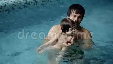 <strong>父亲和儿子在</strong>游泳池里。 年轻的爸爸教他3岁的<strong>儿子</strong>游泳