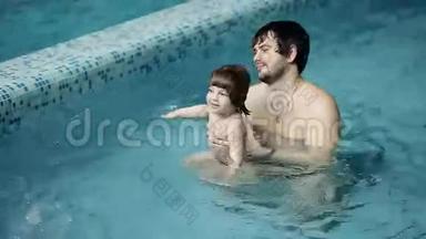 <strong>父亲和儿子在</strong>游泳池里。 年轻的爸爸教他3岁的<strong>儿子</strong>游泳