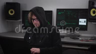 一个电脑室的黑客。 那个戴着眼镜、手提电脑的人试图从外国基地窃取情报