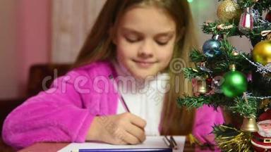 女孩给圣诞老人写了<strong>一封信</strong>，重点放在她面前<strong>的</strong>毛皮树上
