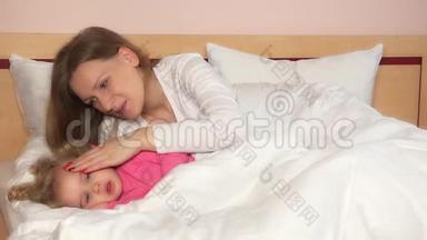 母亲抚摸她躺在床上的<strong>女孩子</strong>，使她入睡。