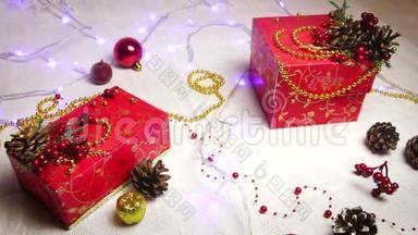 红色手工制作的礼品盒和圣诞装饰品，金色的苹果和带有闪闪<strong>发光灯笼</strong>的凸起物，俯视