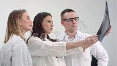 三位年轻医生在看脊柱x线