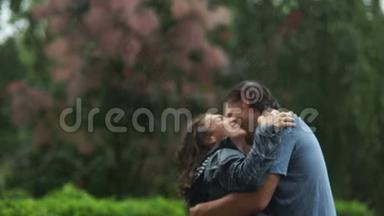 在雨中欢笑情感的<strong>夫妻</strong>拥抱和亲吻。 两个情人很高兴在户外<strong>一起</strong>度过。
