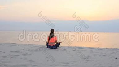 健康，年轻的美丽女子冥想，在海滩上练习瑜伽，海边，日出时，放松肌肉，放松心灵