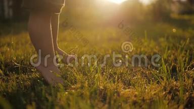 小宝宝学会<strong>走路</strong>.. 动作缓慢。 孩子们在日落时在绿草上做第一步。 快关门