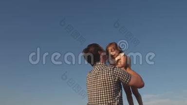 爸爸在蓝天上抛出一个快乐的女儿。 爸爸和小朋友一起玩，一起笑，一起拥抱.. 幸福家庭