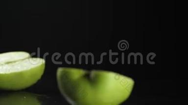 慢动作。 绿色苹果切片落在黑色背景高清。 慢动作。