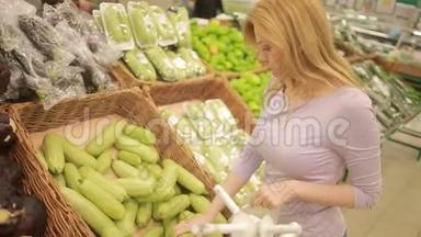 一个女人在超市的<strong>蔬菜货架</strong>上买<strong>蔬菜</strong>，西葫芦