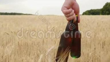 一个人拿着两瓶冷啤酒在一片大麦上。 概念是解渴.. 慢速视频