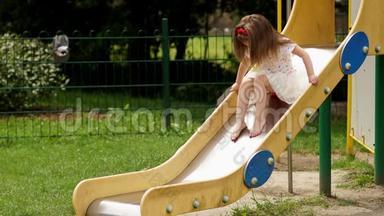 户外可爱的小女孩在夏日阳光明媚的日子里在<strong>游乐场</strong>的儿童滑梯上<strong>玩耍</strong>的肖像。