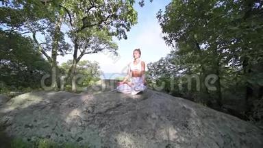 年轻女子正在<strong>一座山</strong>顶上美丽的异国情调的地方练习瑜伽。 瑜伽和冥想