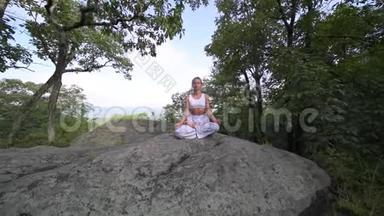 年轻<strong>女子</strong>正在一座山顶上美丽的异国情调的地方练习<strong>瑜伽</strong>。 <strong>瑜伽</strong>和冥想