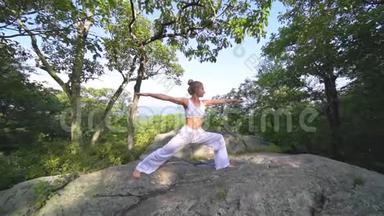 年轻女子正在一座山顶上美丽的异国情调的地方练习瑜伽。 瑜伽和冥想