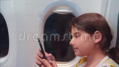<strong>航空飞机</strong>概念。 年轻女孩正坐飞机在窗户旁边聊天，生活方式在看着
