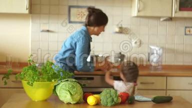一个小女儿帮妈妈在厨房做饭.. 妈妈把女孩抱在怀里，他们一起煮汤。