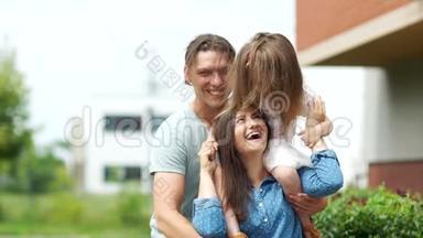 年轻的父母和他们的小女儿。 父亲拥抱他的女孩。 一家人。