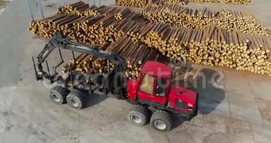 一辆卡车穿过工厂，一个运送原木的记录器在一排排的原木之间穿梭