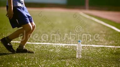 小男孩<strong>足球</strong>运动员在<strong>训练</strong>期间从塑料瓶里喝水。 青少年踢<strong>足球</strong>