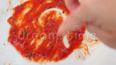 用番茄酱的残留物<strong>清空</strong>脏盘子。 男人`手在番茄酱的残骸上画一颗心。 4k，慢镜头