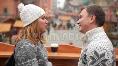 英俊的男人和美丽的女人面对面站在咖啡杯在<strong>圣诞节</strong>市场背景。 恋爱中的<strong>情侣</strong>