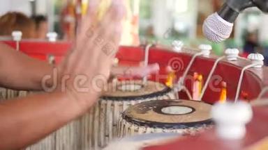 亚洲艺术家在寺庙的仪式上用手在传统的鼓器上敲鼓。 4，快点。 泰国。