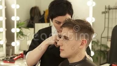 理发店用电动剃须刀理发的理发师。 将理发器与理发机合拢