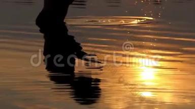 年轻人在棕榈树上<strong>掀起</strong>河水，看着它在金色的夕阳下