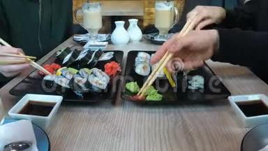一群人在一家<strong>餐馆</strong>吃一套大型寿司，<strong>坐在</strong>一张时髦的桌子旁。 时间流逝