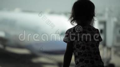 儿童在机场靠窗看飞机，等待飞行时间